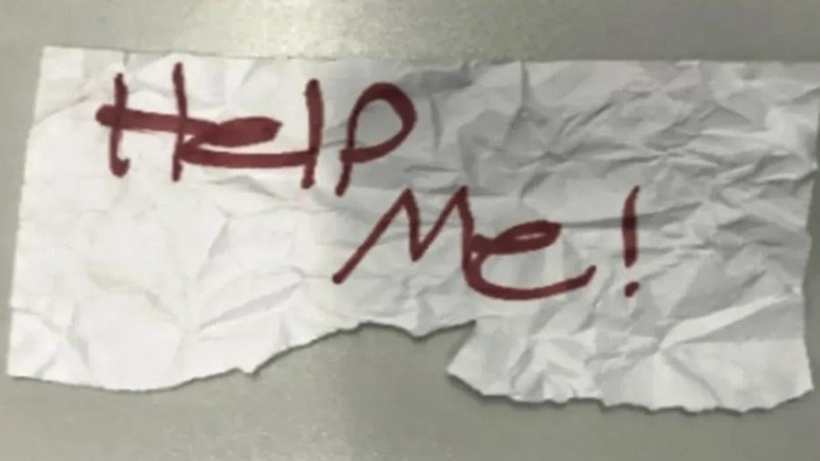 Bilhete escrito "Help Me", que significa "Me ajuda", foi usado por menina para pedir por socorro