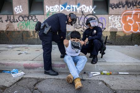 Polícia de Los Angeles apreendendo detém manifestante durante protesto pró-imigração Polícia de Los Angeles apreendendo detém manifestante durante protesto pró-imigração