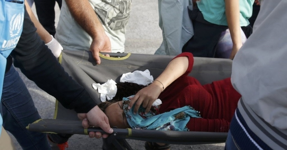 16.set.2015 - Mulher é ferida durante um protesto de imigrantes que não conseguiram atravessar da Sérvia para a Hungria. A polícia húngara usou gás lacrimogêneo e canhões de água contra os manifestantes
