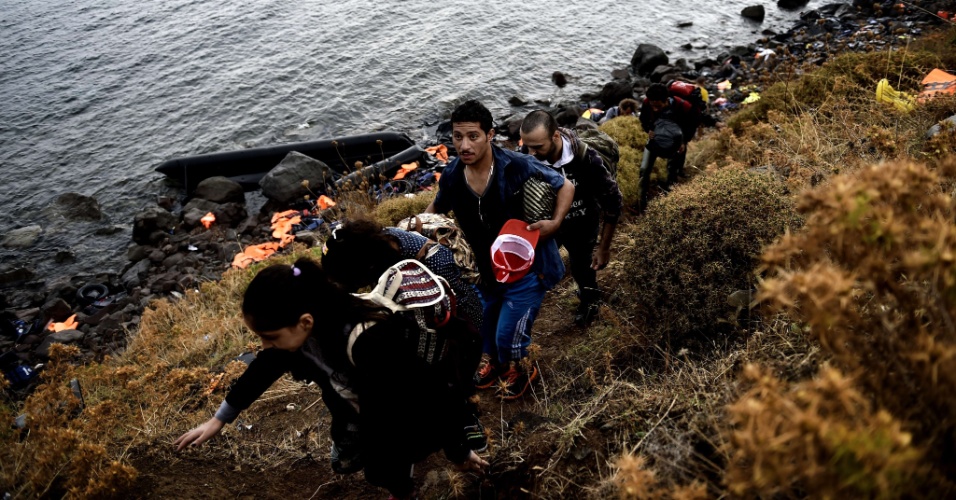 28.set.2015 - Refugiados sírios sobem colina na ilha de Lesbos, na Grécia, depois de atravessarem o mar Egeu, vindos da Turquia. Uma embarcação com imigrantes afundou e deixou dezenas de mortos