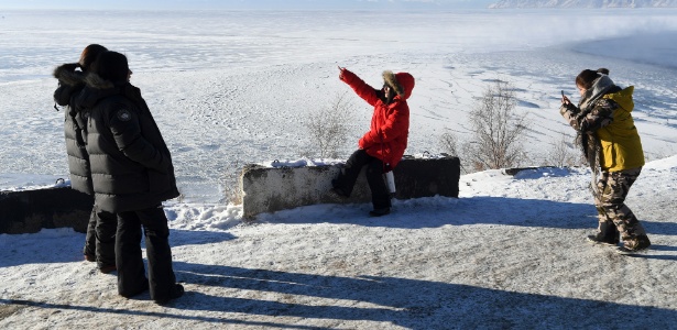 Turistas chineses tiram foto na margem ocidental do lago Baikal, próximo a Listvyanka - James Hill/The New York Times