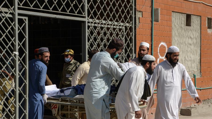 Homens empurram uma maca carregando uma vítima ferida em uma explosão de bomba em uma escola religiosa, em um hospital em Peshawar, no Afeganistão - Abdul Majeed/AFP