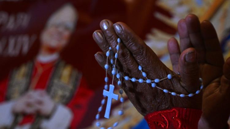Mulher reza ao lado da imagem de Robert Prevost, que se tornou Papa Leão 14, em frente à catedral de Chiclayo, Peru Mulher reza ao lado da imagem de Robert Prevost, que se tornou Papa Leão 14, em frente à catedral de Chiclayo, Peru