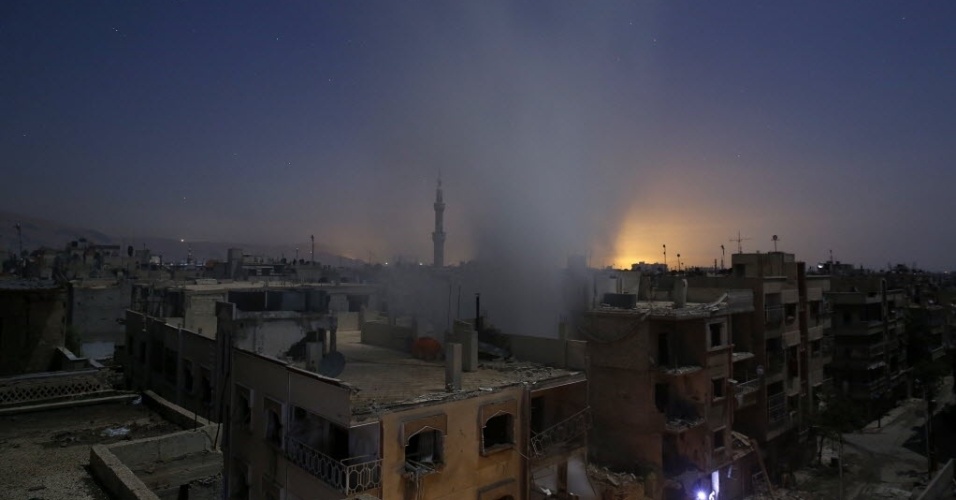 30.out.2015 - Coluna de fumaça surge próximo a edifícios em Douma, a leste de Damasco, na Síria, depois de bombardeio realizado pelas forças do governo sírio
