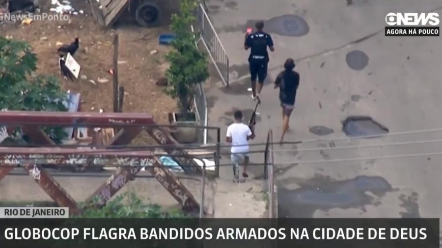 2.dez.2019 - Homens armados fogem da polícia durante operação da PM na Cidade de Deus, no Rio de Janeiro - Reprodução/Globonews