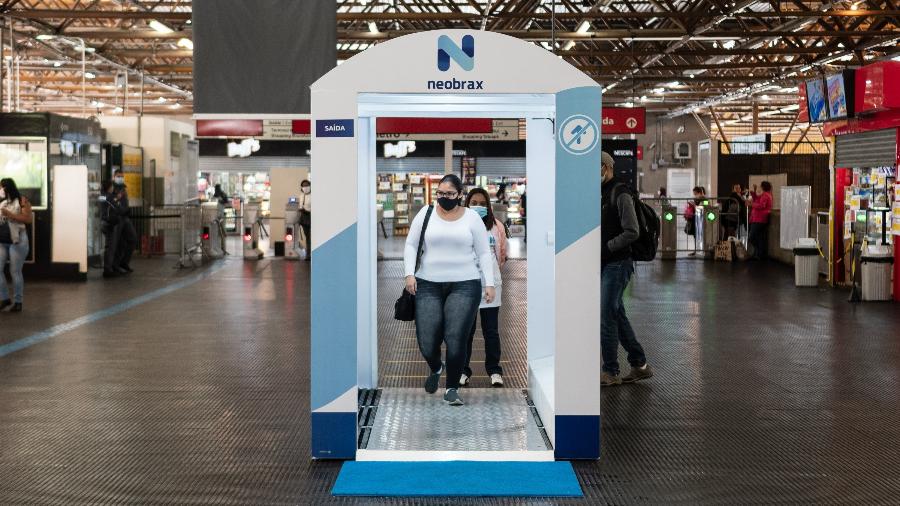 4.mai.2020 - Passageiros do metrô de São Paulo utilizando a cabine de desinfecção individual - Estadão Conteúdo