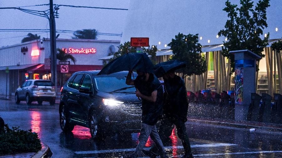 8.nov.2020 - Pessoas atravessam a rua em Miami durante chuva e ventos intensos conforme a tempestade Eta se aproxima da Flórida, nos Estados Unidos - Chandan Khanna/AFP