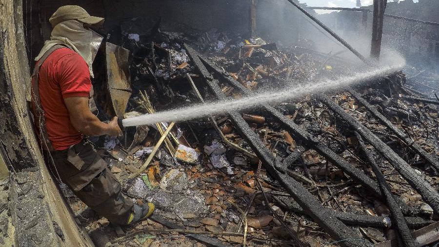 Bombeiro tenta conter incêndio em imóvel do Sistema Nacional de Emprego, que servia de arquivo no bairro Barra do Ceará, periferia de Fortaleza - 06.jan.2019 - Jarbas Oliveira/Folhapress