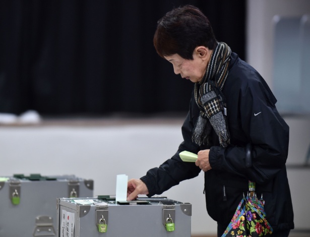 Mulher deposita seu voto em urna em Tóquio, durante eleições gerais no Japão - Kazuhiro Nogi/AFP Photo