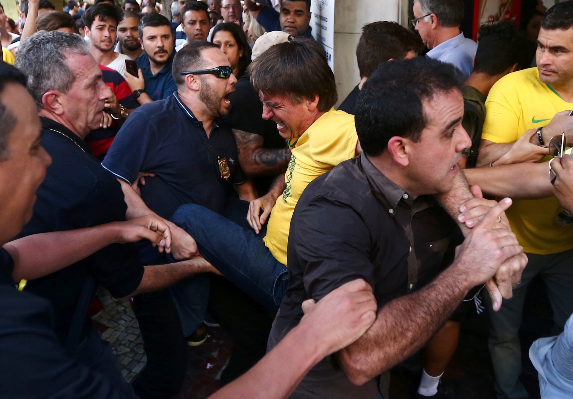 6.set.2018 - O candidato à Presidência da República pelo PSL, Jair Bolsonaro (de camiseta amarela), após ser esfaqueado durante ato de campanha em Juiz de Fora (MG), nesta quinta-feira, 06. O presidenciável foi levado para o hospital. Antes do ataque, tumultos, tensão e bate-boca marcaram a visita de Bolsornaro ao hospital filantrópico da Associação Feminina de Prevenção e Combate ao Câncer (ASCOMCER) e também um almoço com o candidato em um hotel em Juiz de Fora, Minas Gerais, hoje - FÁBIO MOTTA/ESTADÃO CONTEÚDO