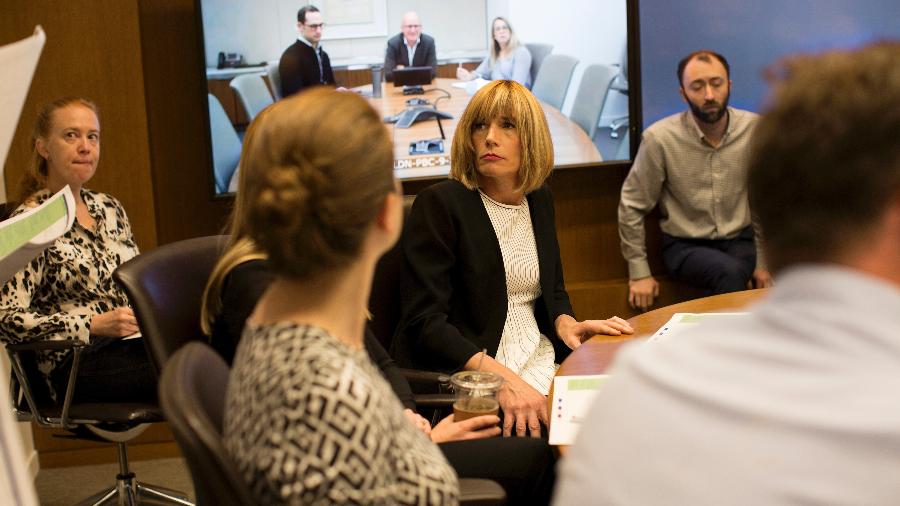 Maeve DuVally, no centro, e seus colegas de trabalho participam da reunião matinal de comunicação e marketing na sede do Goldman Sachs, em Nova York - Gabriella Angotti-Jones/The New York Times