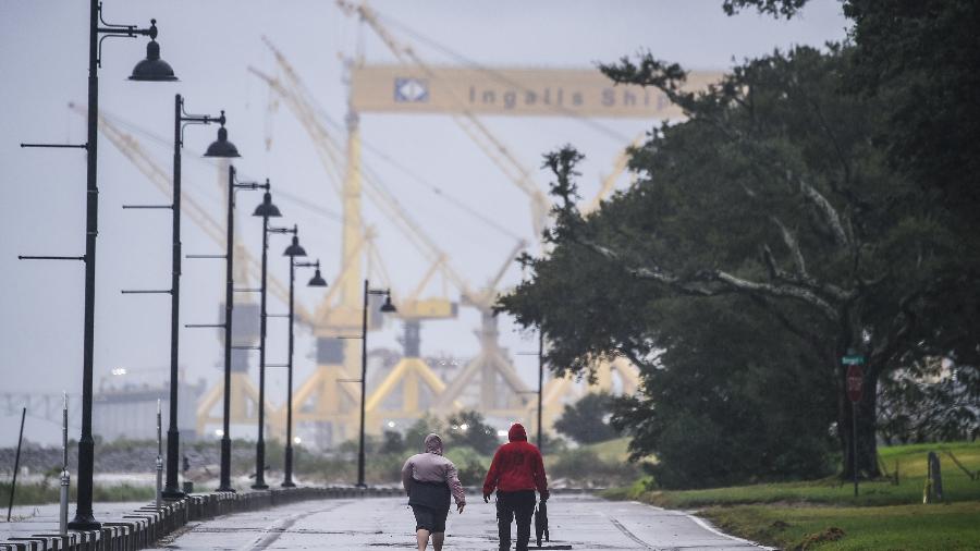 15.set.2020 - Moradores caminham em via costeira horas antes de o furacão Sally atingir os Estados Unidos, em Pascagoula, Mississippi - Chandan Khanna/AFP
