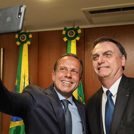 23.abr.2019 - João Doria (PSDB), governador de São Paulo, tira uma foto com o presidente Jair Bolsonaro (PSL) após encontro entre os dois no Palácio do Planalto, em Brasília - Marcos Corrêa/PR