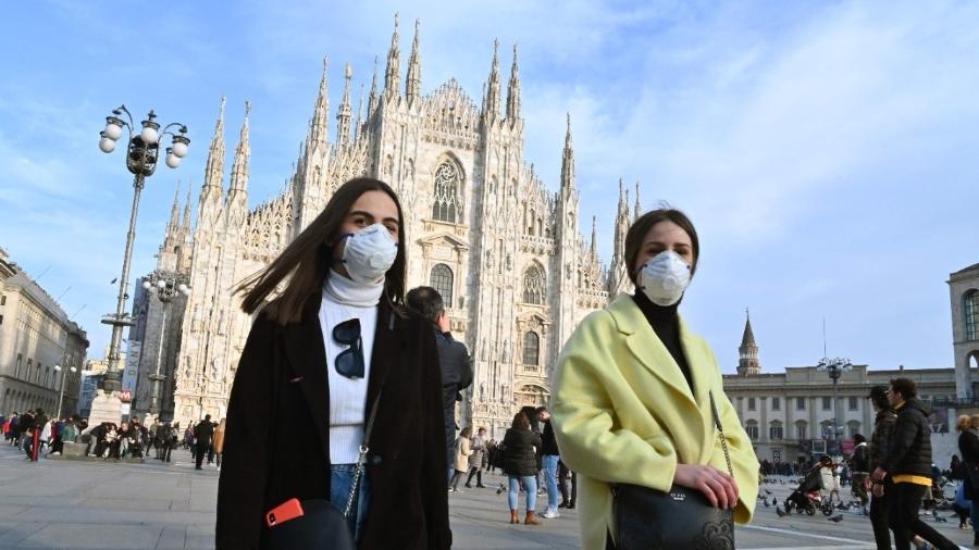 Mulheres usam máscara no rosto na Piazza del Duomo, no centro de Milão - Andreas Solaro/AFP