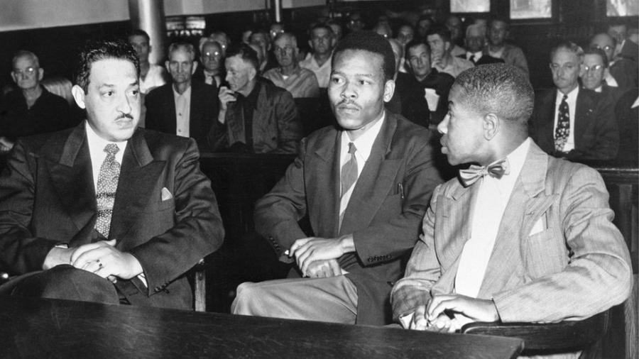 Walter Irvin, um dos quatro homens perdoados, conversa com seus advogados em seu novo julgamento em 1952 - Getty Images