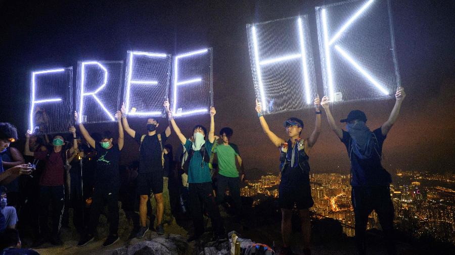 10.out.19 - Ativistas pró-democracia seguram letras iluminadas por LED que lêem "Free HK" enquanto formavam uma corrente humana em Lion Rock em Hong Kong - Anthony Wallace/AFP