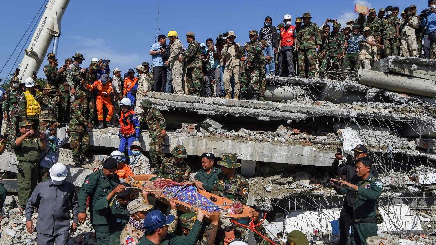 Resgate leva um sobrevivente no local em que um prédio em construção desabou no Camboja - TANG CHHIN SOTHY/AFP