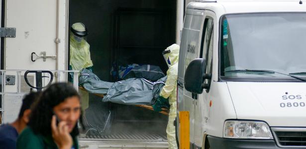 04.jan.2021- Funcionários do Hospital Pronto-Socorro João Lúcio retiram corpo de vítima da covid-19 de contêiner frigorífico, em Manaus