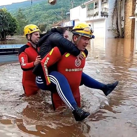 6.set.2023 - Bombeiros carregam mulher após resgate causado por chuvas na cidade de Muçum, no Rio Grande do Sul