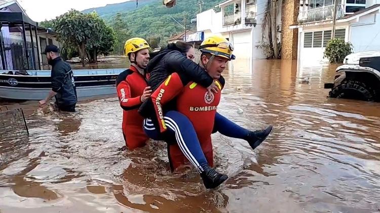 6.set.2023 - Bombeiros carregam mulher após resgate causado por chuvas na cidade de Muçum, no Rio Grande do Sul