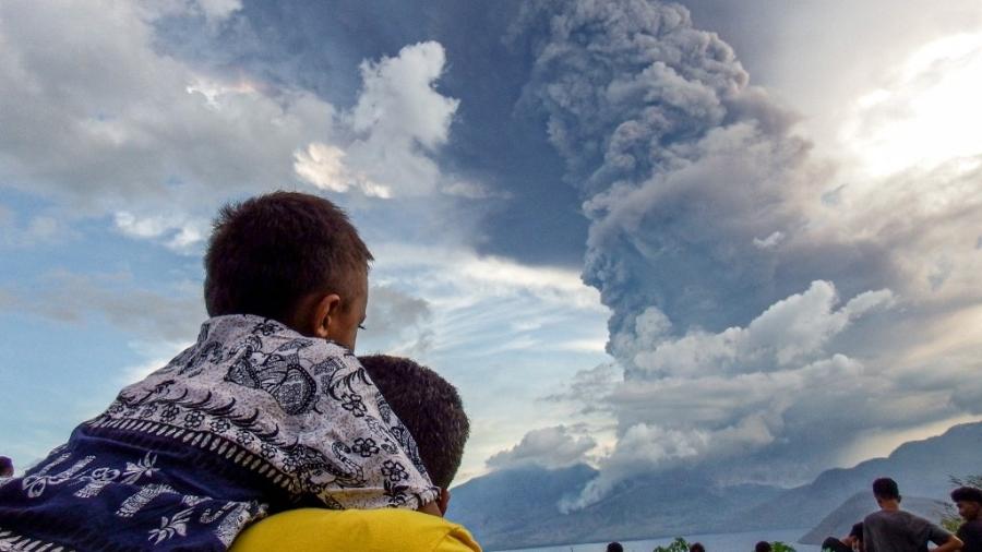 Moradores assistem à erupção do Monte Lewotobi Laki Laki na vila de Eputobi em Titihena, East Nusa Tenggara, em 8 de novembro de 2024