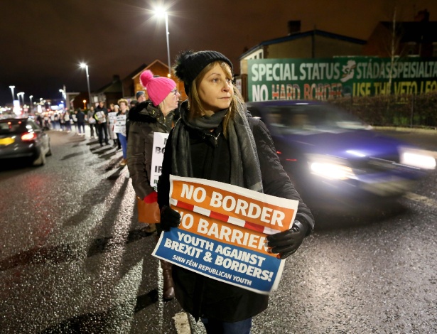 Manifestantes protestam em uma estrada com cartazes anti-Brexit, no oeste de Belfast, na Irlanda - PAUL FAITH/AFP