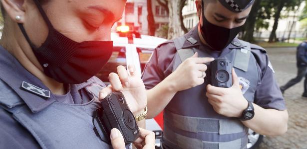 Policiais militares mostram câmeras instaladas nos uniformes, em São Paulo