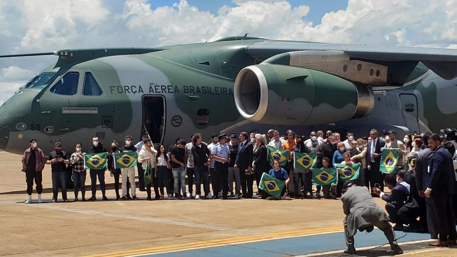 Brasileiros resgatados da Ucrânia posam ao lado do presidente Jair Bolsonaro após desembarcarem em Brasília - Eduardo Militão/UOL