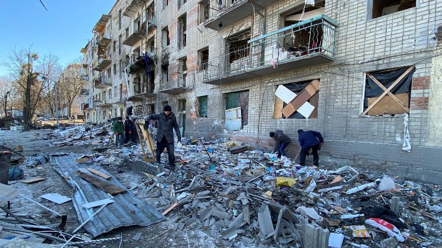 21.mar.2022 - Servidores da Ucrânia e voluntários removem destroços de prédio residencial em Kharkiv, na Ucrânia - REUTERS/Vitalii Hnidyi