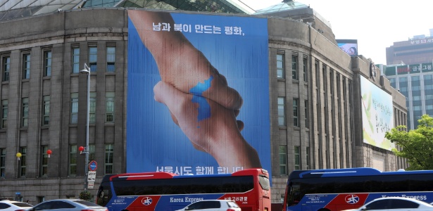 Um dia antes do encontros dos presidentes das duas Coreias, cartaz em Seul, a capital do sul, comemora a aproximação das nações.  - Li Peng/Xinhua