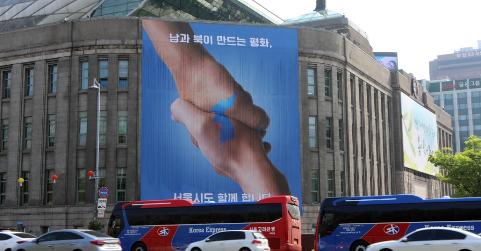 Um dia antes do encontros dos presidentes das duas Coreias, cartaz em Seul, a capital do sul, comemora a aproximação das nações. 