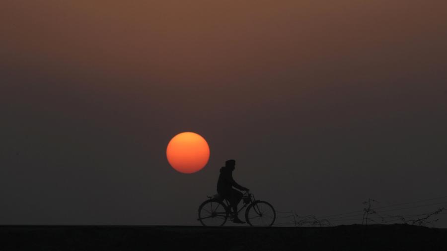 31.dez.2018 - Homem anda de bicicleta durante último pôr do sol de 2018 em Lahore, no Paquistão - Mohsin Raza/Reuters