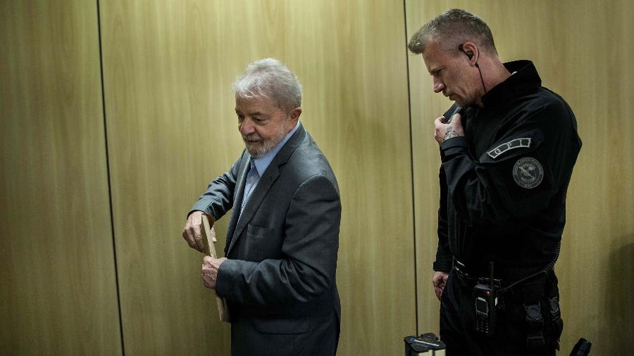 O agente Jorge Chastalo Filho conduz o ex-presidente Lula a entrevista, na sede da Polícia Federal, em Curitiba (PR) - Marlene Bergamo/Folhapress
