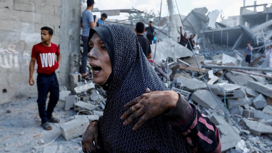 Mulher palestina em meio a destroços de casas após ataque israelense em Rafah, no sul da Faixa de Gaza 