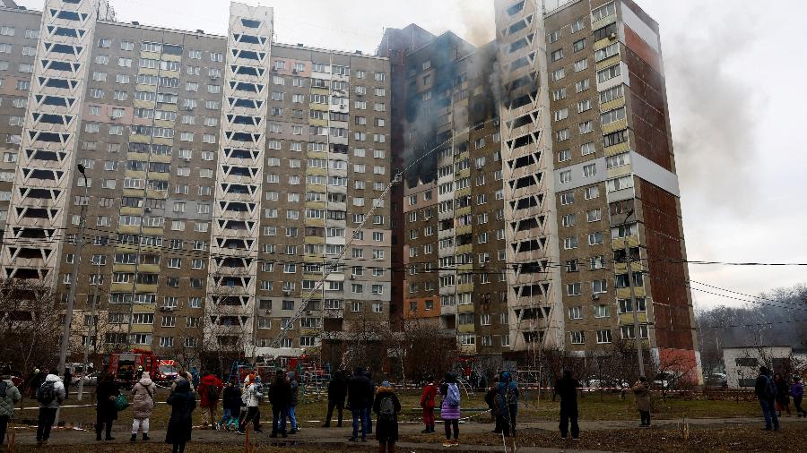 07.fev.24 - Moradores observam trabalho dos bombeiros após prédio ser atingido por ataque de míssil russo em Kiev, Ucrânia