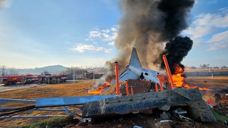 Bombeiros apagam fogo que começou em avião após batida em muro na Coreia do Sul