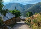 Imagem de uma pequena vila montanhosa na Espanha, representando Quintela.