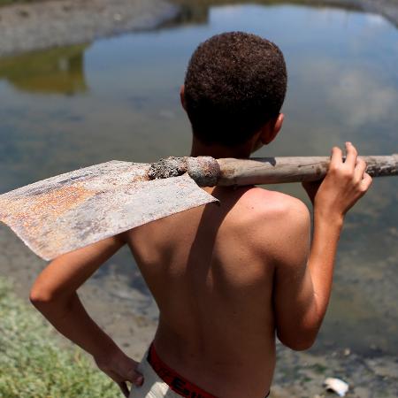 Criança trabalha em água poluida do rio Capibaribe, no Recife - Diego Herculano/Folhapress