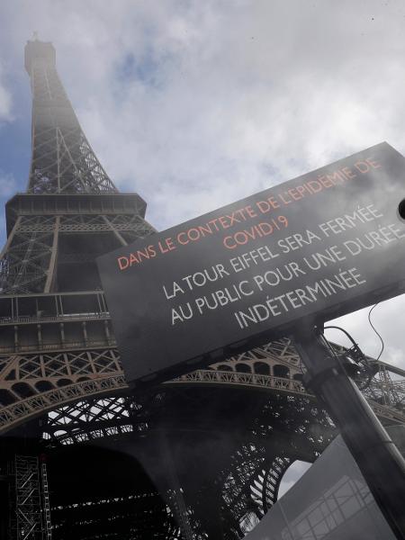 Placa em frente à torre Eiffel alerta visitas proibidas como medida de cautela contra o coronavírus - Thomas Samson/AFP