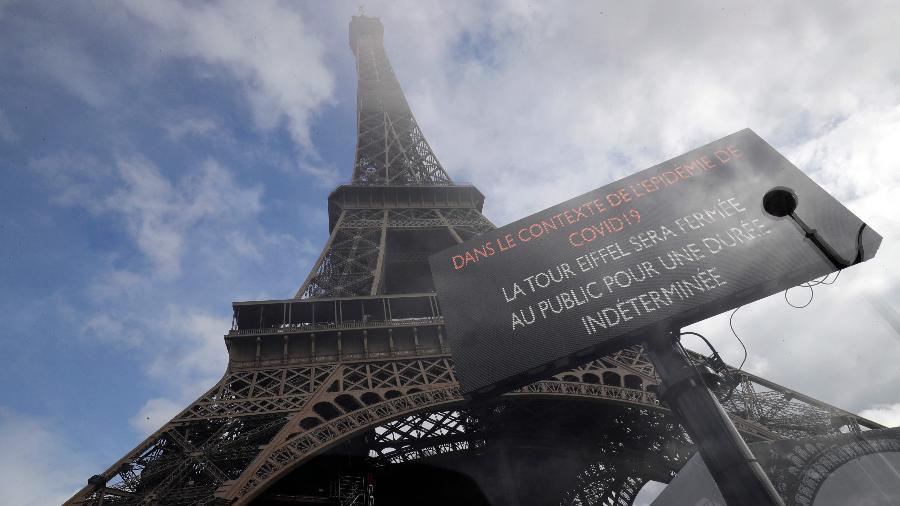 Imagem mostra placa em frente à torre Eiffel, um dos cartões-postais de Paris (França), alertando que visitas proibidas como medida de cautela em relação ao coronavírus - Thomas Samson/AFP