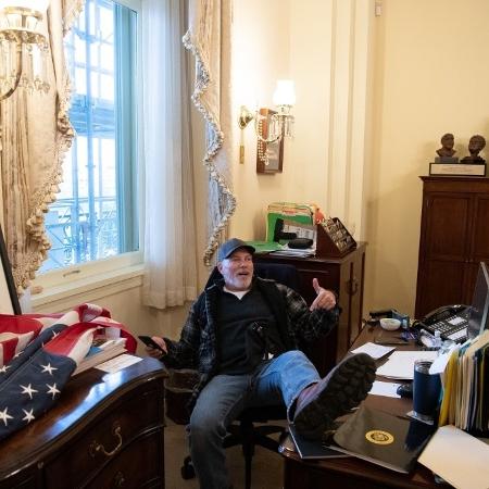 Apoiador de Donald Trump, Richard Barnett foi fotografado com o pé em cima da mesa de Nancy Pelosi, presidente da Câmara dos EUA - Saul Loeb/AFP