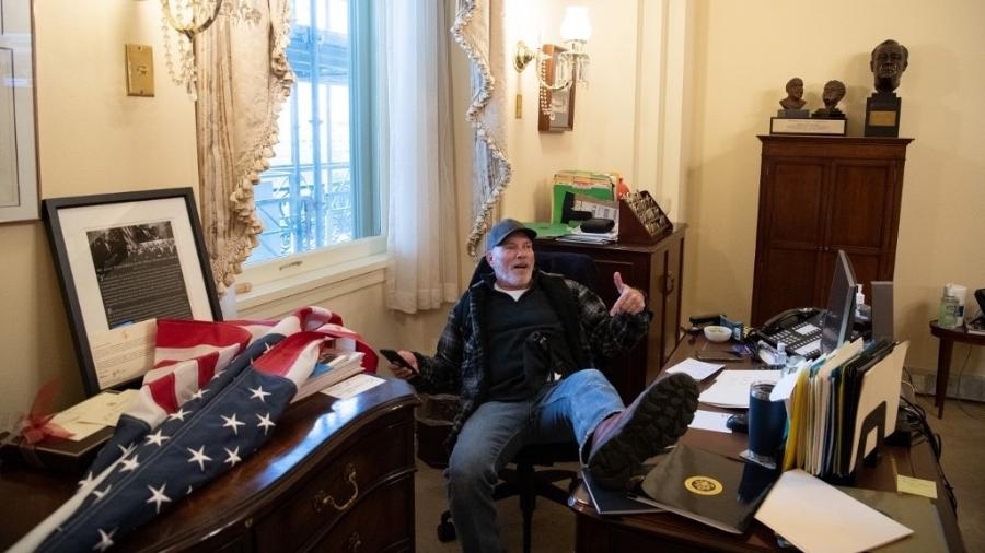 Richard Barnett foi fotografado com o pé em cima da mesa de Nancy Pelosi, presidente da Câmara dos EUA - Saul Loeb/AFP