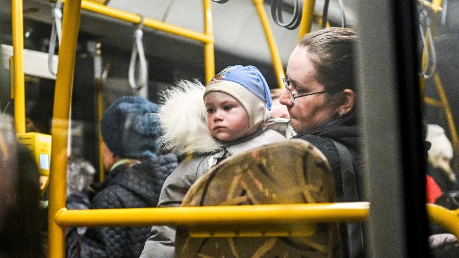 1.abr.2022 - Uma mulher segura uma criança dentro de um ônibus enquanto as pessoas fogem de Mariupol e Melitopol em meio ao ataque da Rússia à Ucrânia, em um ponto de coleta em Zaporizhzhia, Ucrânia - Stringer/Reuters