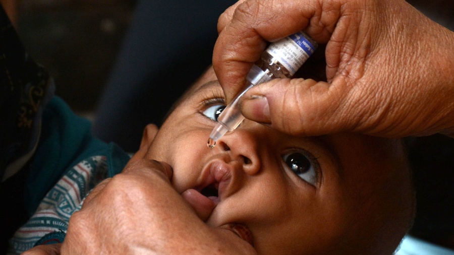 25.out.2016 - Trabalhador da saúde aplica vacina contra a poliomielite em uma criança no Dia Mundial da Pólio em Lahore, no Paquistão - Sajjad/Xinhua