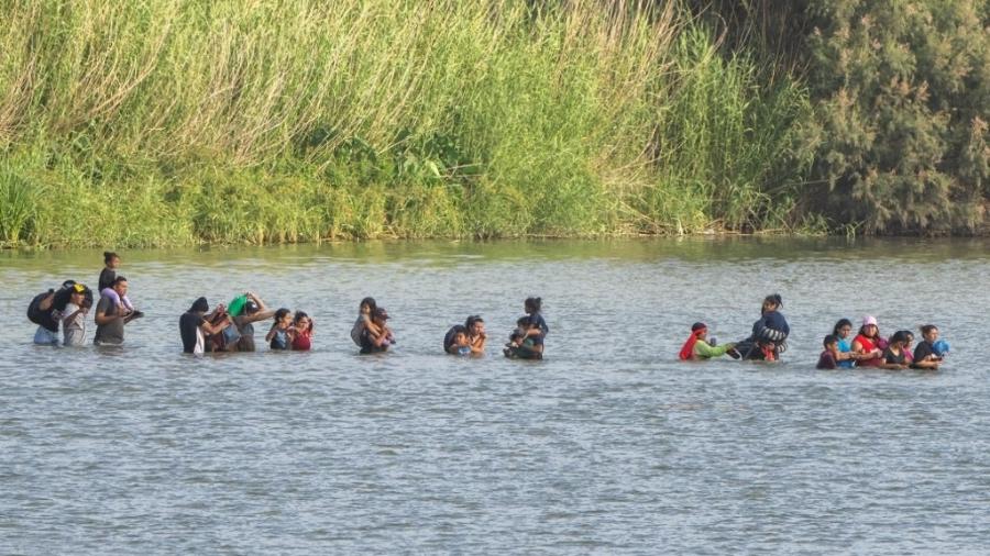Grupo de imigrantes cruza o rio Grande, na fronteira entre o México e os Estados Unidos