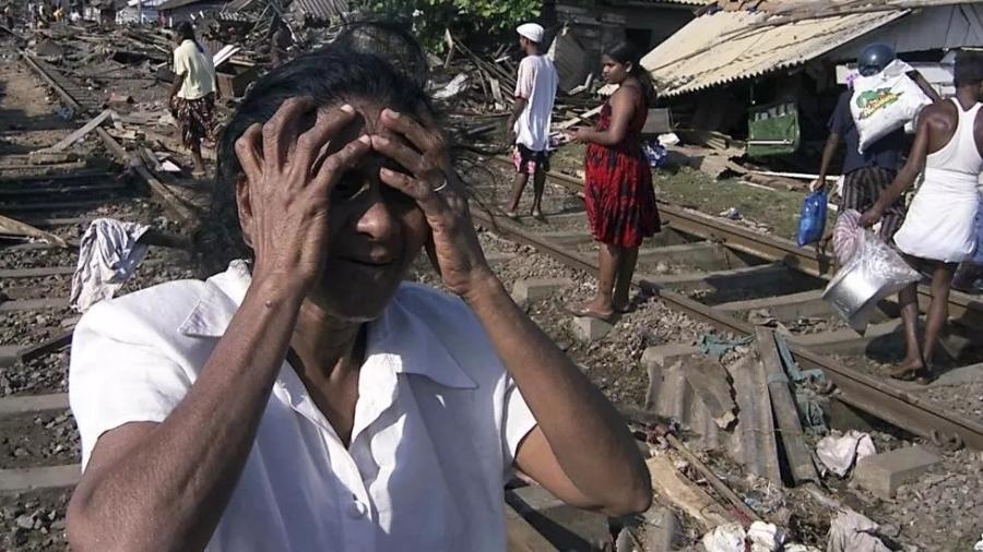 Uma mulher do Sri Lanka chora em frente à sua casa destruída na área costeira de Colombo, em 26 de dezembro de 2004, quando ocorreu o tsunami  - AP - ERANGA JAYAWARDENA