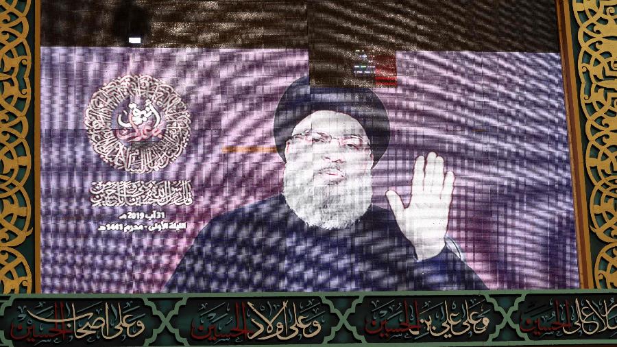O líder xiita do Hezbollah, Hasan Nasrallah, teve discurso transmitido em um telão no subúrbio de Beirute, capital do Líbano.  - Anwar Amro/AFP