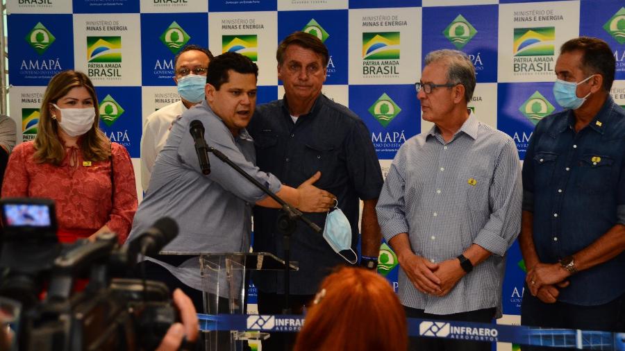 O presidente Jair Bolsonaro é abraçado pelo presidente do Senado, Davi Alcolumbre, no Aeroporto Internacional de Macapá - Erich Macias/Futura Press/Estadão Conteúdo