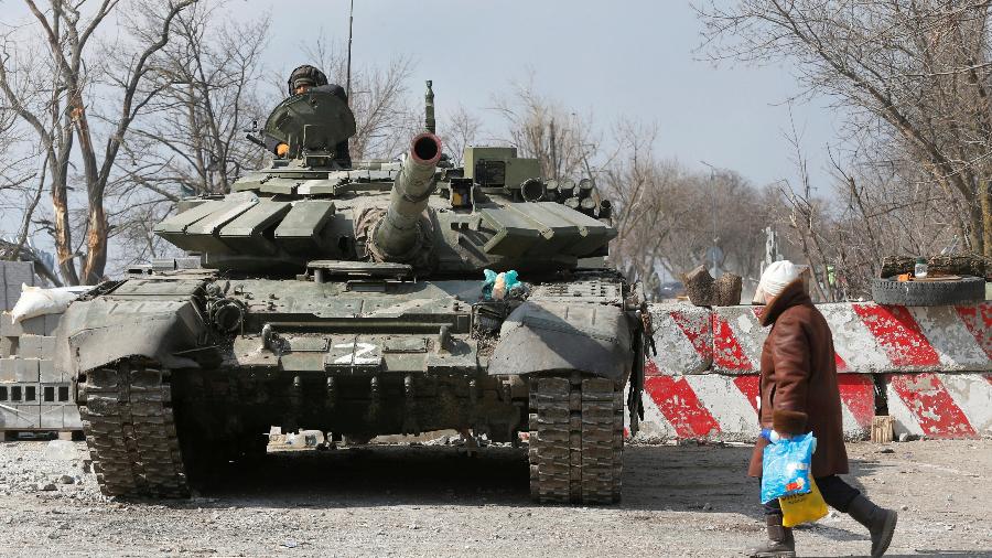 18.mar.2022 - Morador local passa por um tanque de tropas pró-Rússia, na cidade de Mariupol, na Ucrânia - Alexander Ermochenko/ Reuters