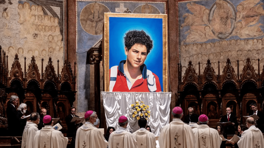 Tapeçaria com retrato de Carlo Acutis pendurada na Basílica de São Francisco de Assis durante a cerimônia de beatificação - Reprodução/Vaticano